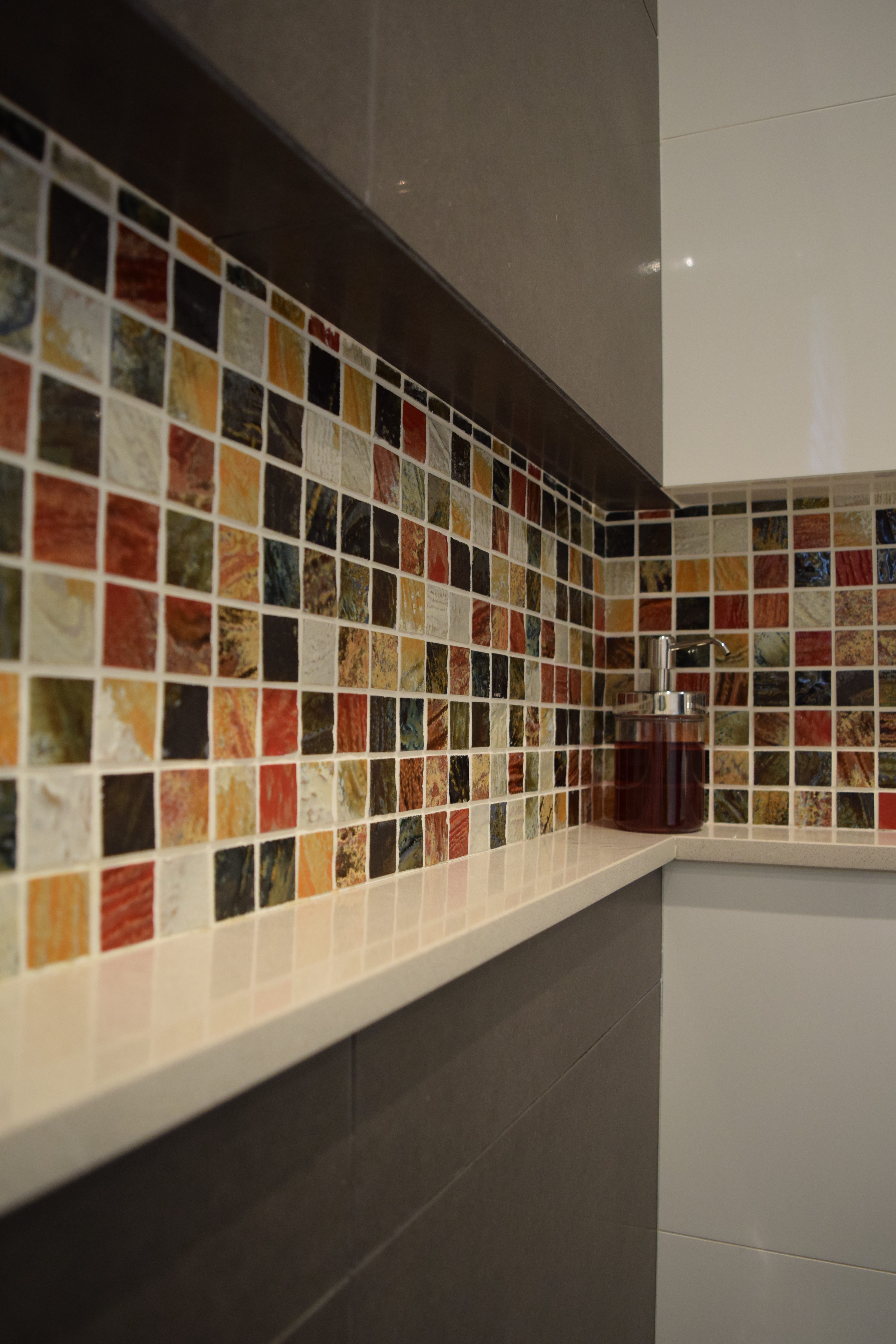 Modern bathroom with shower niche containing colourful mosaic tiles